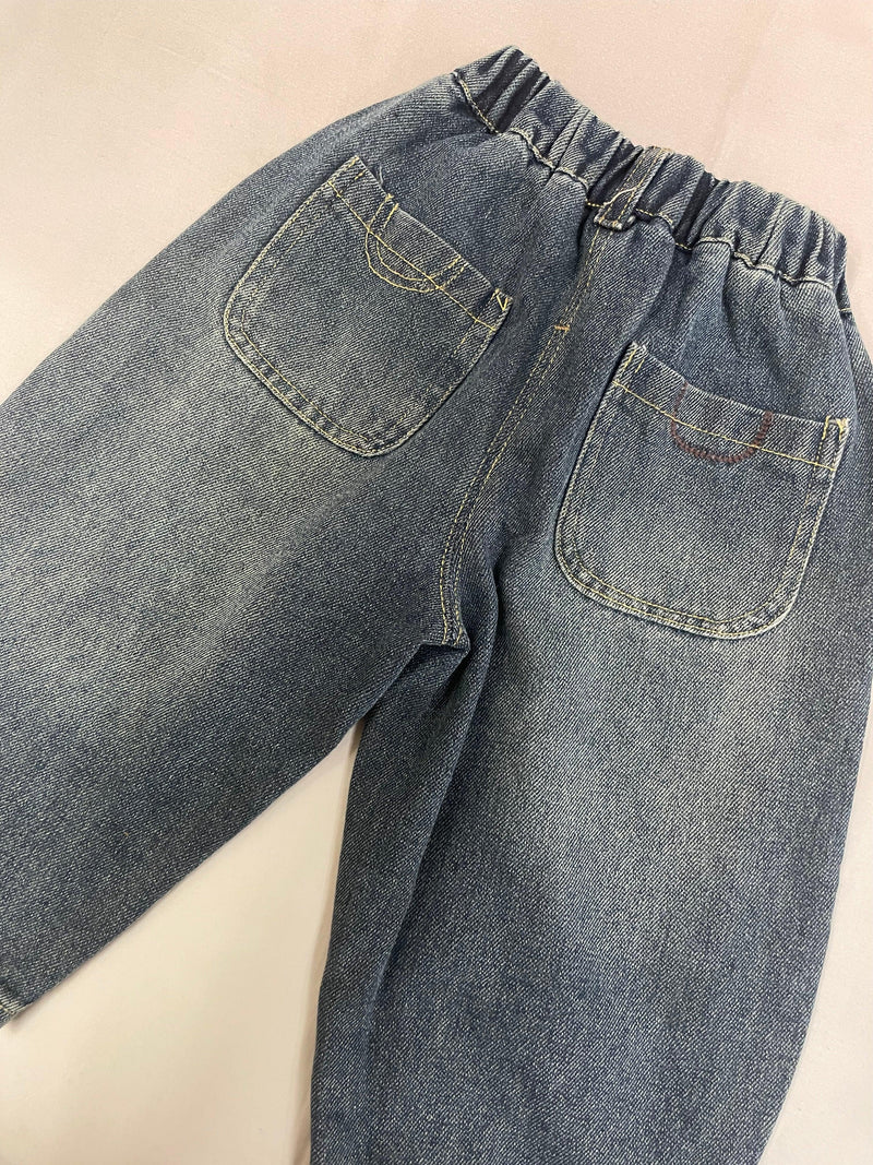 Angled view of blue Korean denim pants for kids by Little Aangan