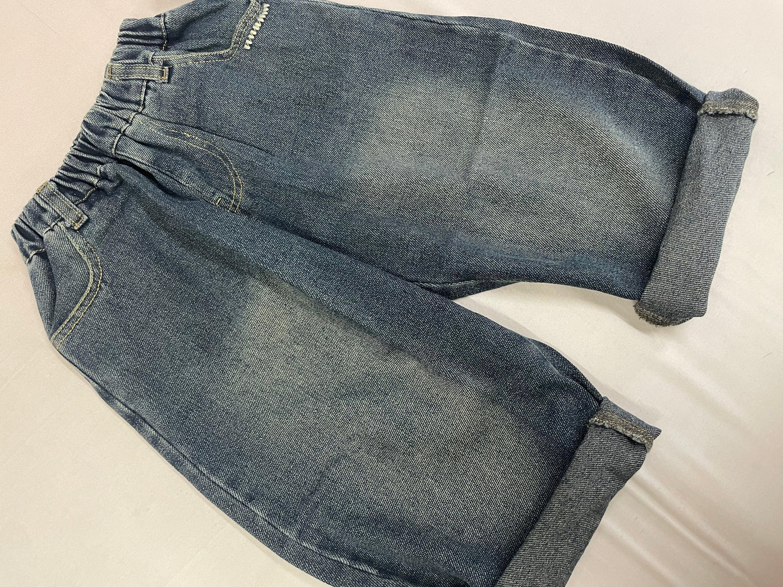 Folded view of blue Korean denim pants showing fabric finish by Little Aangan
